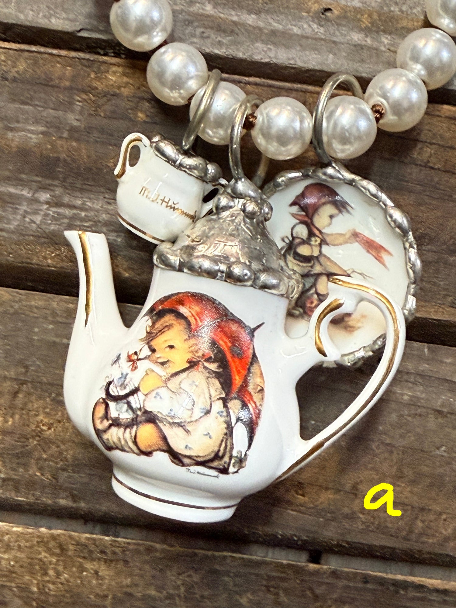 Decorative teapot with child design on a wooden surface