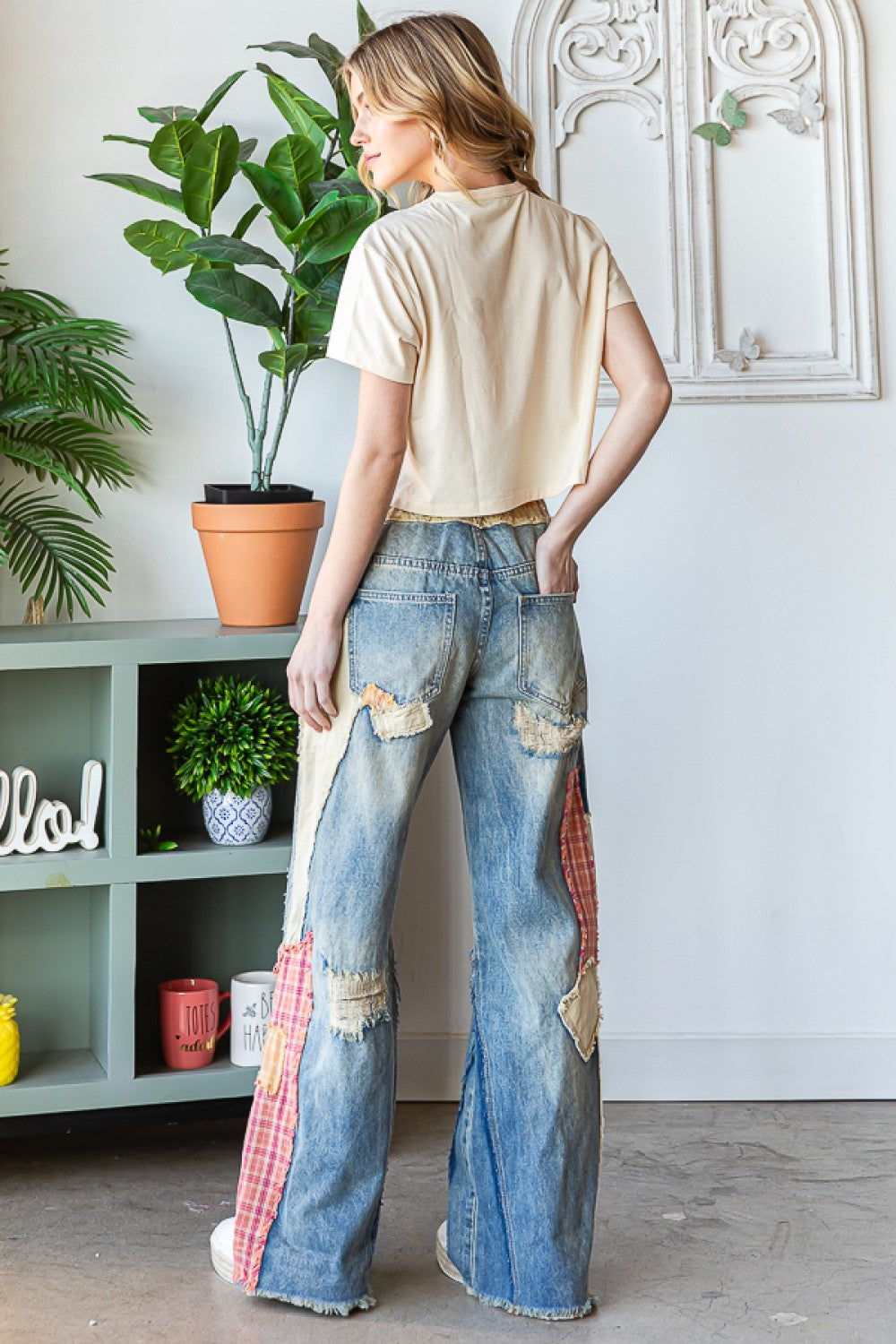 back view of patch detail wide straight denim pants on a model.