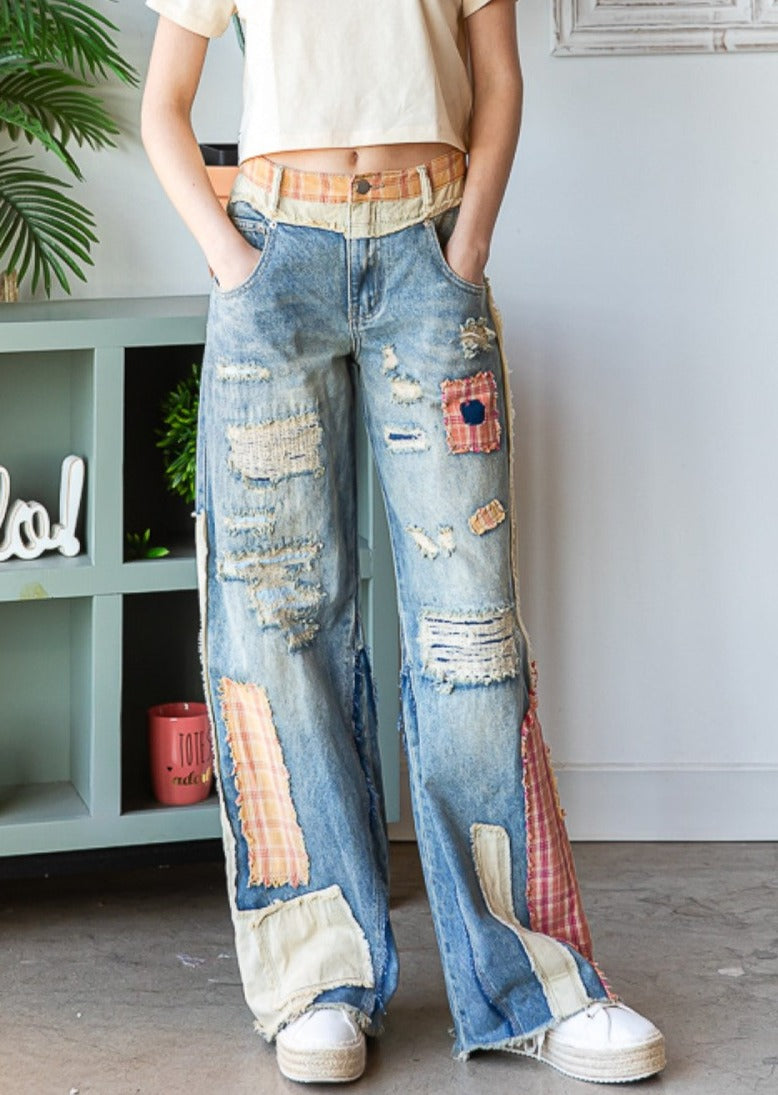 front view of patch detail wide straight denim pants on model with hands in front pockets.