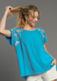 Front view of model wearing the Linen Round Neck Hi-Lo Hem Embroidery top.