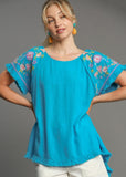 Front view of model wearing Linen Round Neck Hi-Lo Hem Embroidery Top.