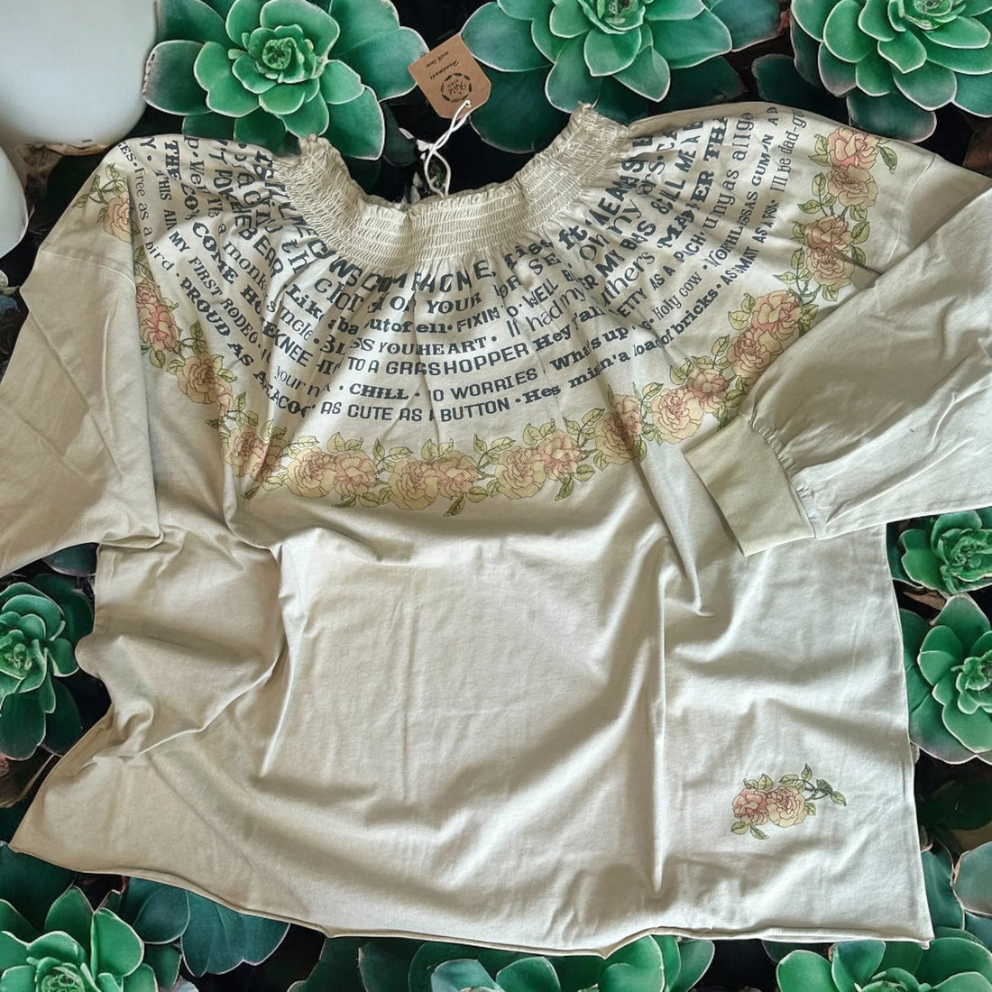 Beige blouse with floral print on a green leaf background