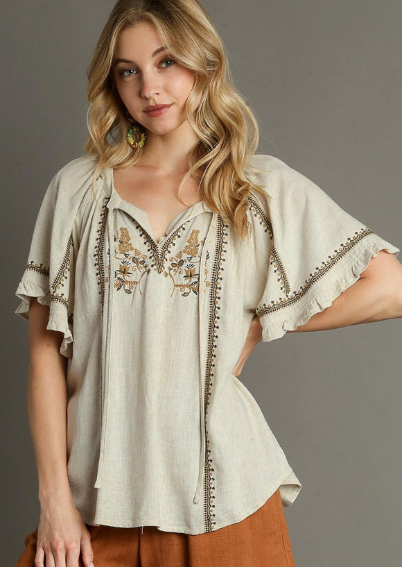 Front view of Linen Peasant Top with Embroidery on a model.