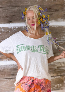 Front view of model wearing Inner Peace T shirt.  Graphic reads "Inner Peace" printed in a green color.