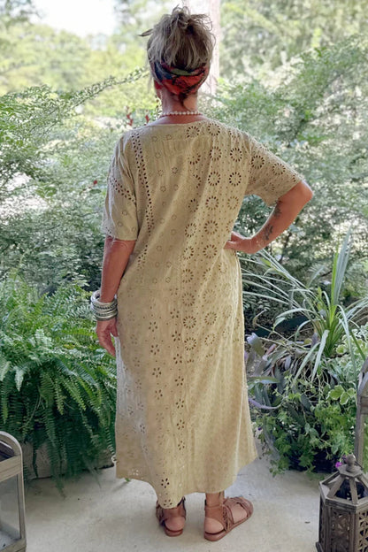 Woman in a beige patterned dress standing in a garden