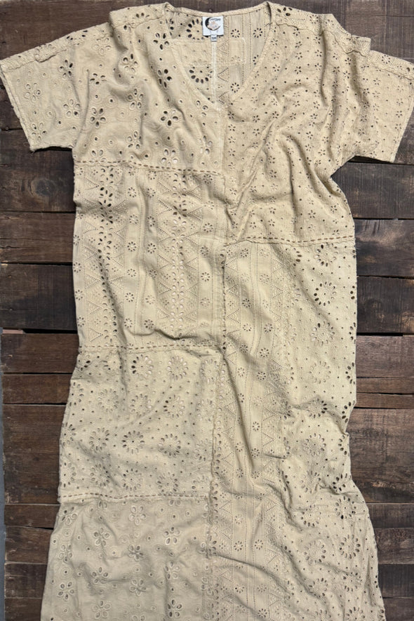 Beige embroidered dress on a wooden surface