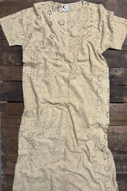 Beige embroidered dress on a wooden surface