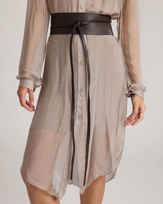 Beige dress with a dark brown belt on a plain background