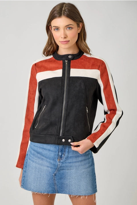 Woman wearing a color-blocked jacket with red, black, and white sections on a plain background.