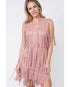 A woman wearing a mauve sleeveless v-neck suede fringe dress.