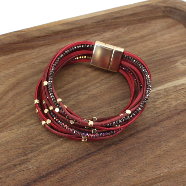 Multistrand bracelet with red and black beads on a wooden surface