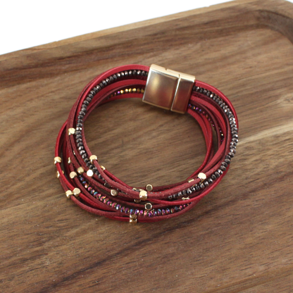 Multistrand bracelet with red and black beads on a wooden surface