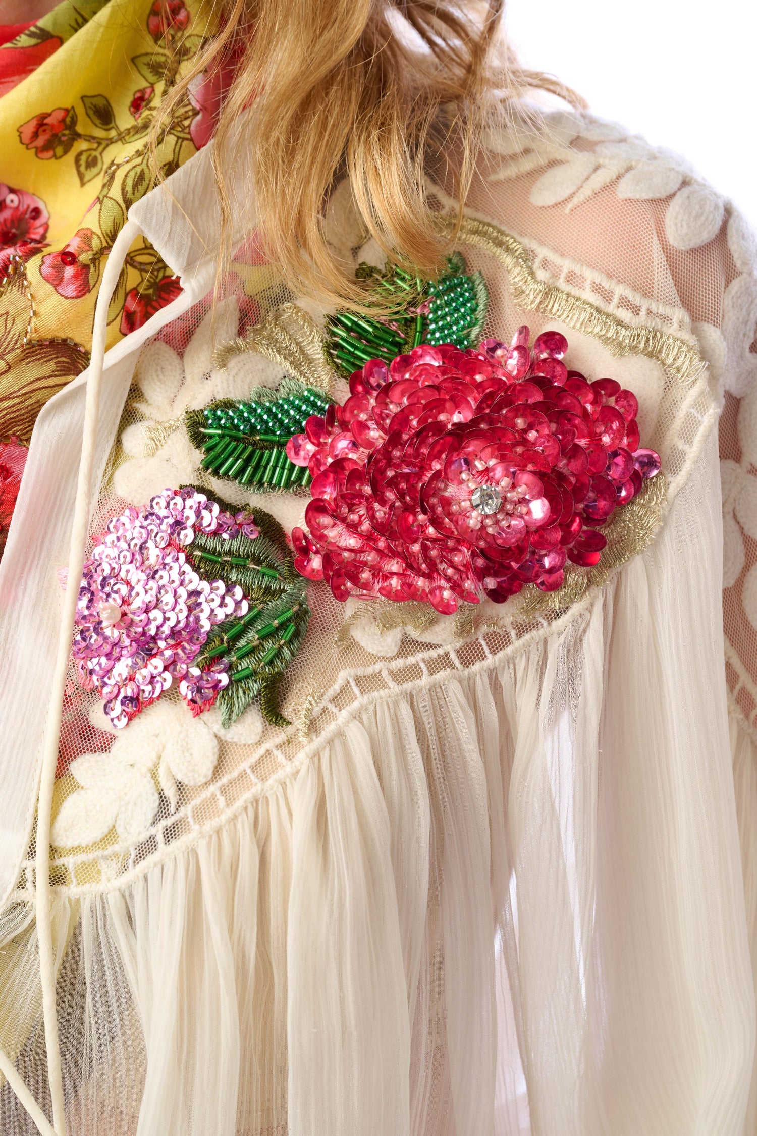 Close-up of a decorative garment with floral patterns and sequins.